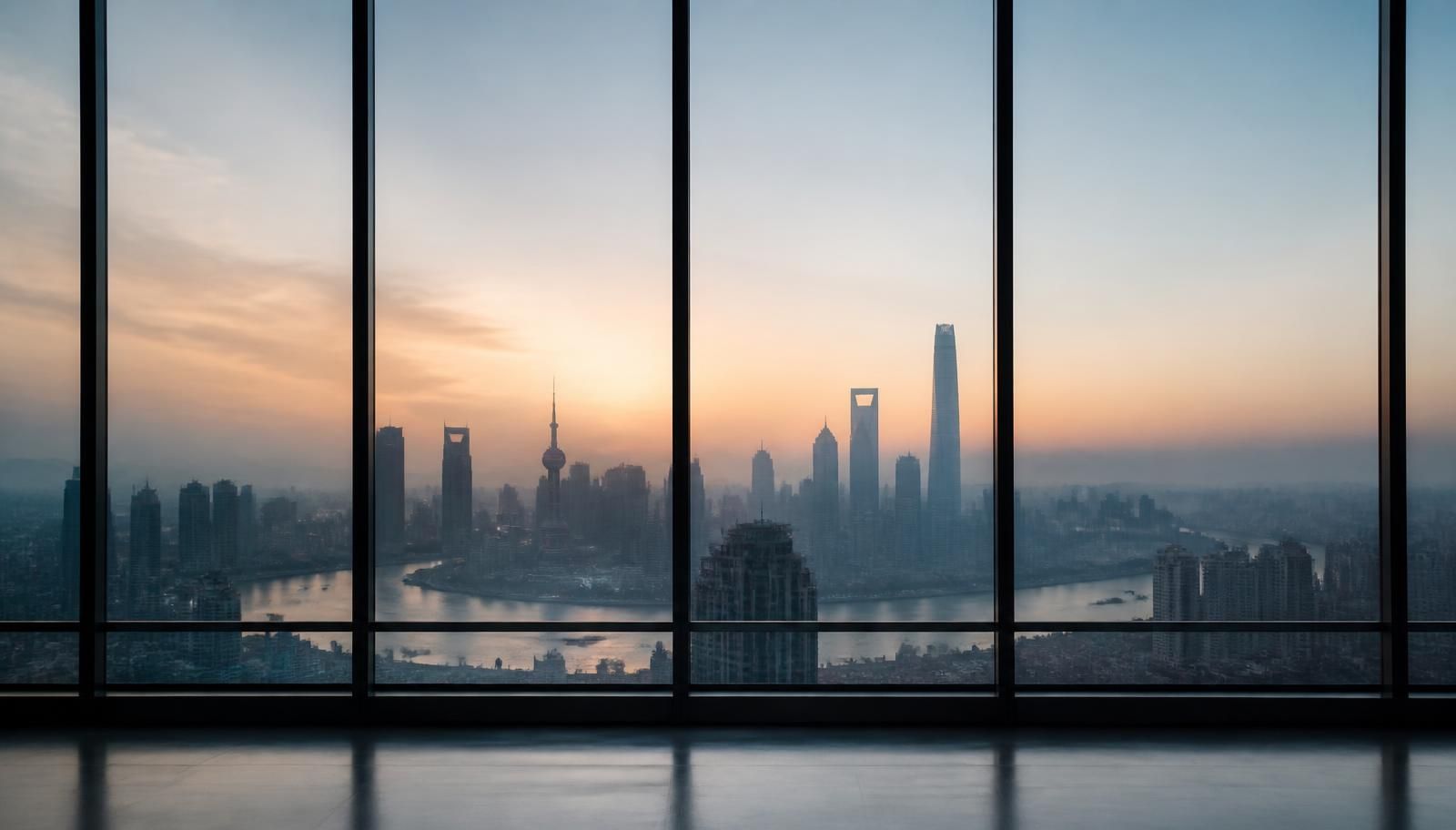 Modern city skyline at dawn seen through a large glass facade
